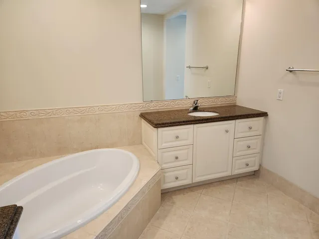 a spacious bathroom with a granite countertop sink and mirror