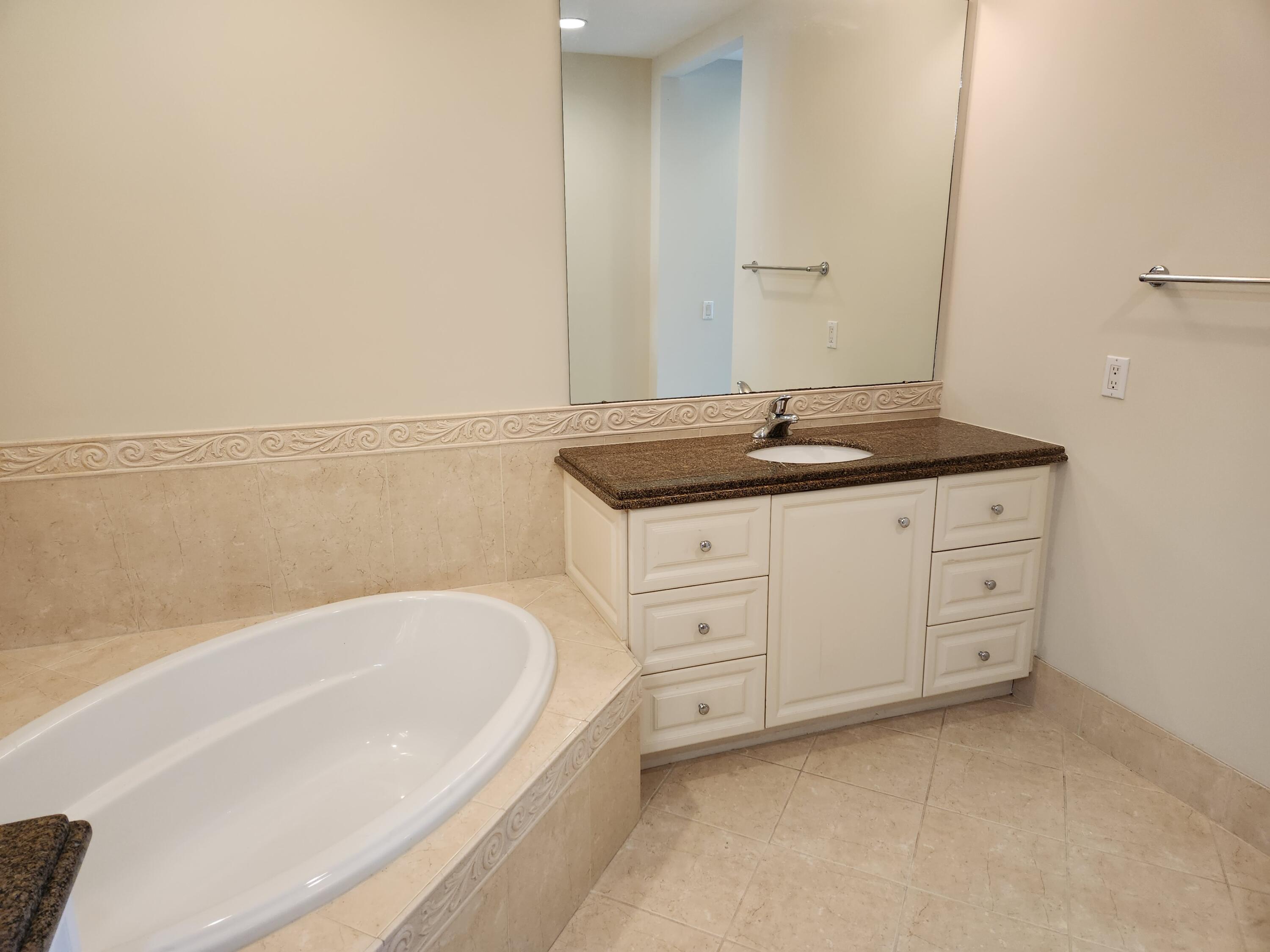 10 Harbour Isle Drive East, Unit 303 Fort Pierce, FL 34949 - Photo 13 of 31 a spacious bathroom with a granite countertop sink and mirror