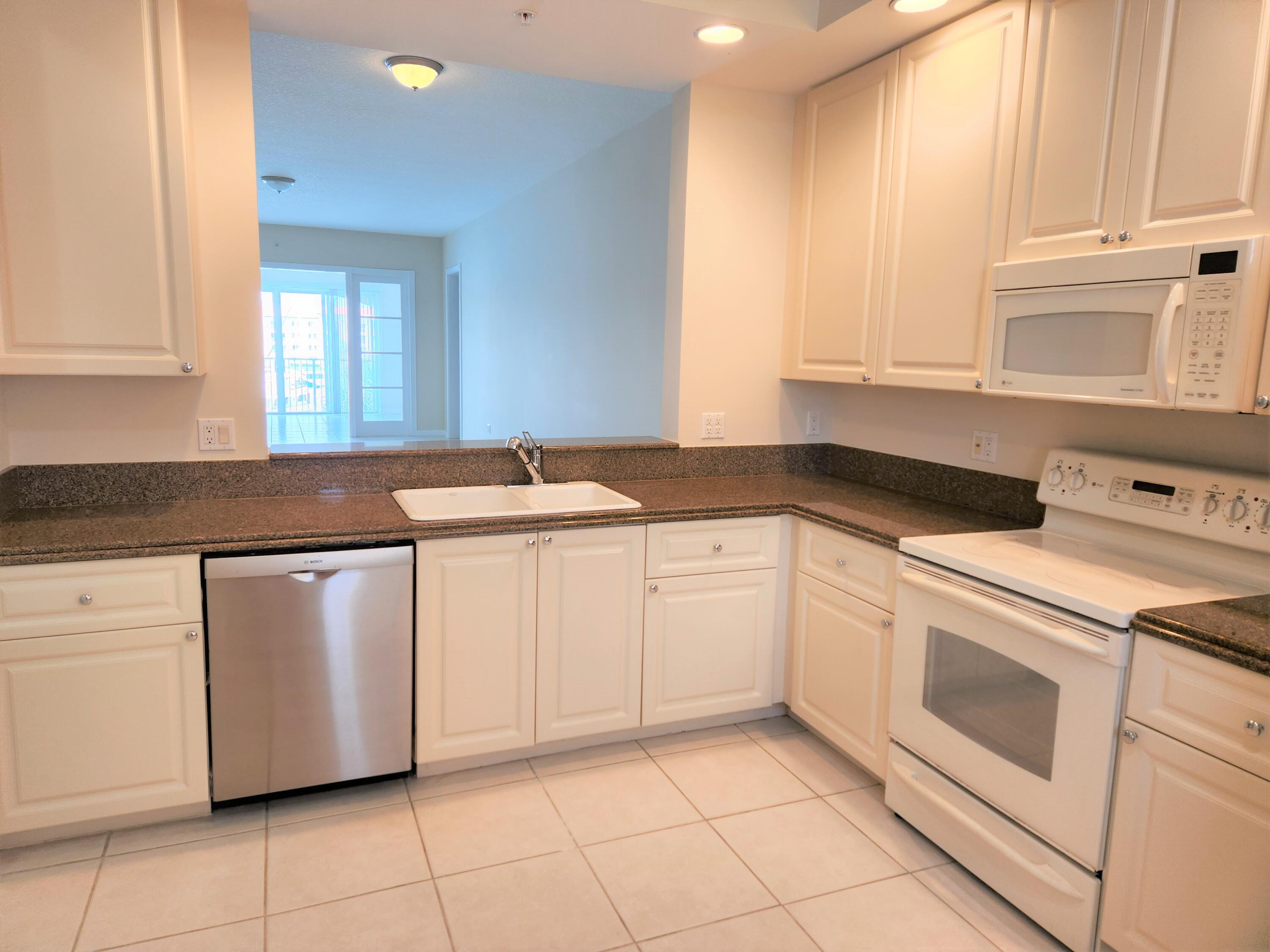 10 Harbour Isle Drive East, Unit 303 Fort Pierce, FL 34949 - Photo 2 of 31 a kitchen with granite countertop white cabinets and white appliances