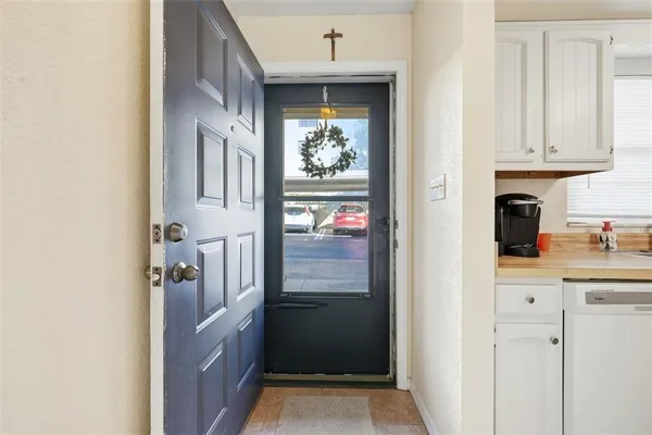 a kitchen with white cabinets and refrigerator