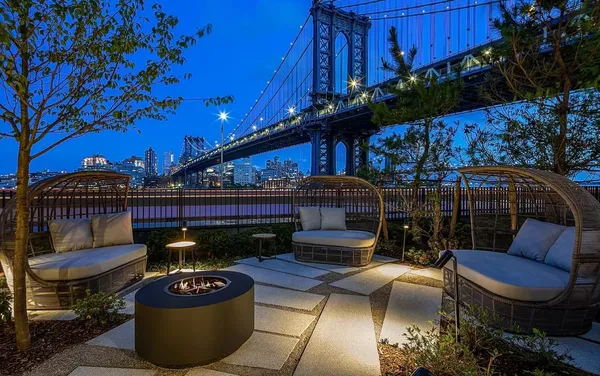a view of a roof deck with couches and wooden fence