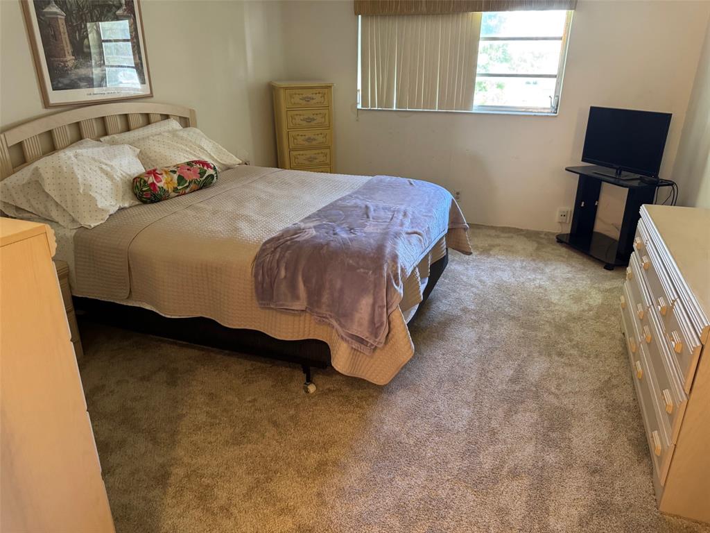 1801 Northwest 75th Avenue, Unit 306 Plantation, FL 33313 - Photo 19 of 27 a bedroom with a bed chair and a window