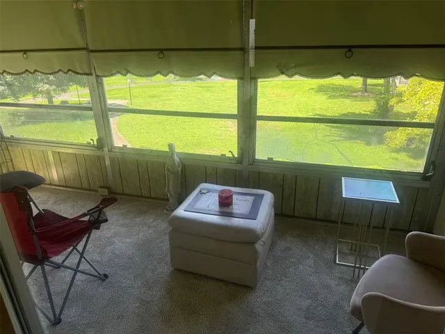 a living room with a floor to ceiling window and a table