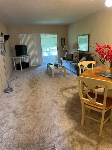 a living room with furniture a window and a flat screen tv