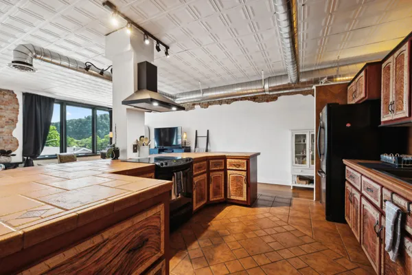 a large kitchen with stainless steel appliances granite countertop a stove and cabinets