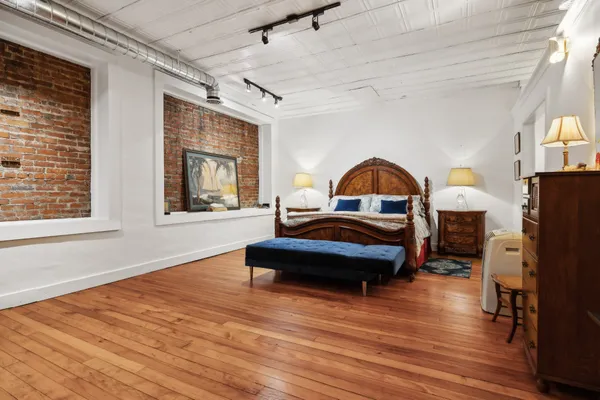 a bedroom with furniture and wooden floor