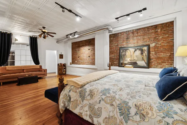 a spacious bedroom with a bed window and couch