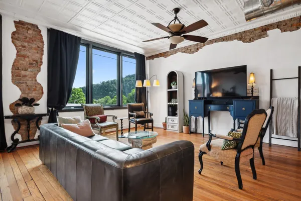 a living room with furniture a flat screen tv and a large window