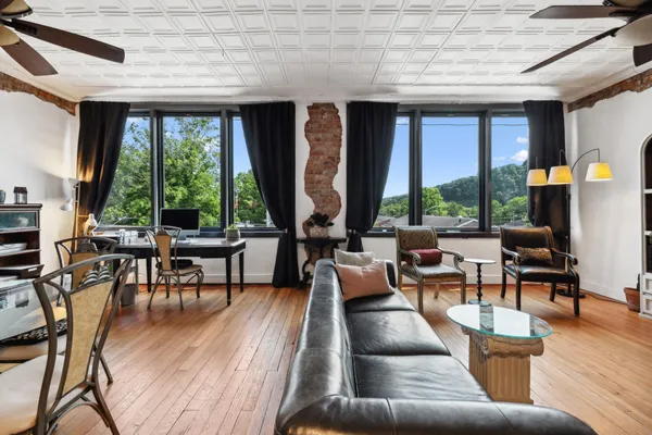 a living room with fireplace furniture and a large window