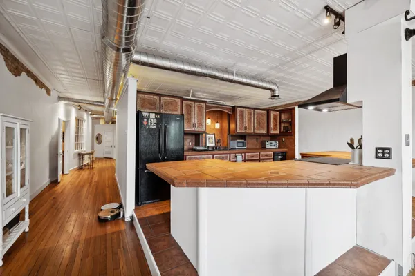 a dining hall with stainless steel appliances granite countertop a sink and wooden floor