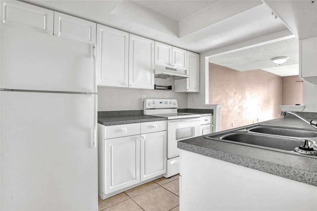 3514 Dairy Road, Unit 10 Titusville, FL 32796 - Photo 18 of 44 a kitchen with granite countertop white cabinets and white appliances