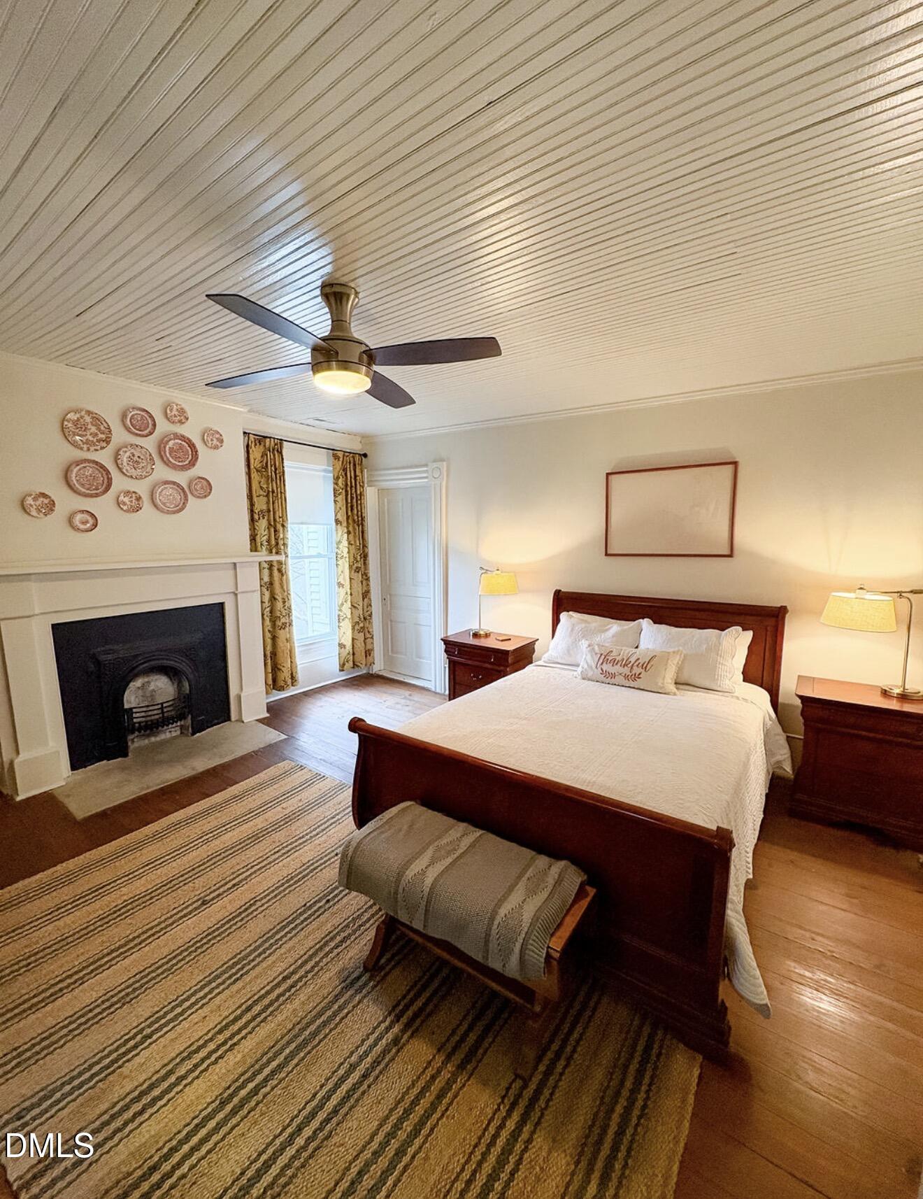 190 Broad Street Milton, NC 27305 - Photo 36 of 62 a spacious bedroom with a bed and a fireplace