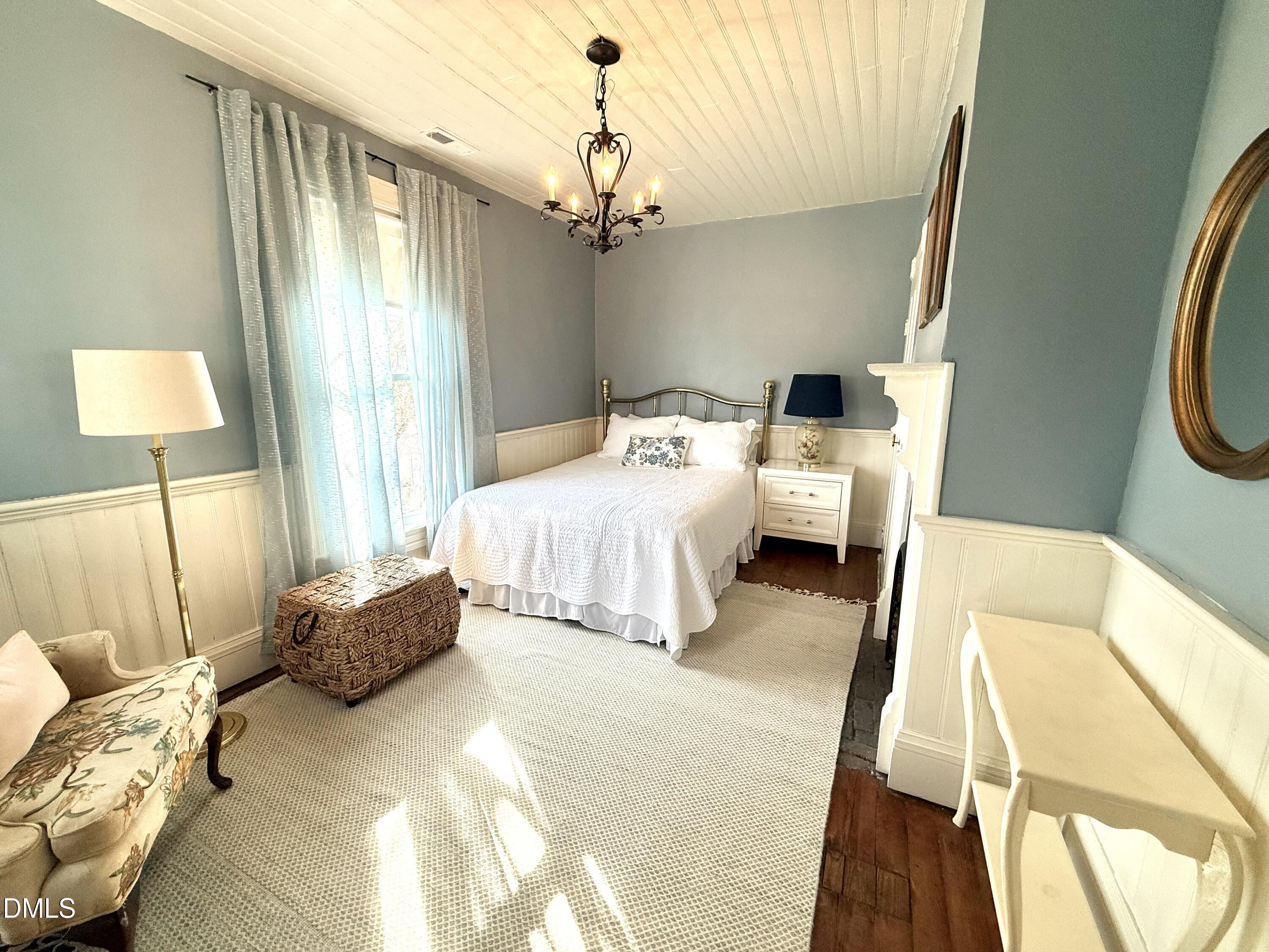 190 Broad Street Milton, NC 27305 - Photo 44 of 62 a bedroom with a bed and a chandelier