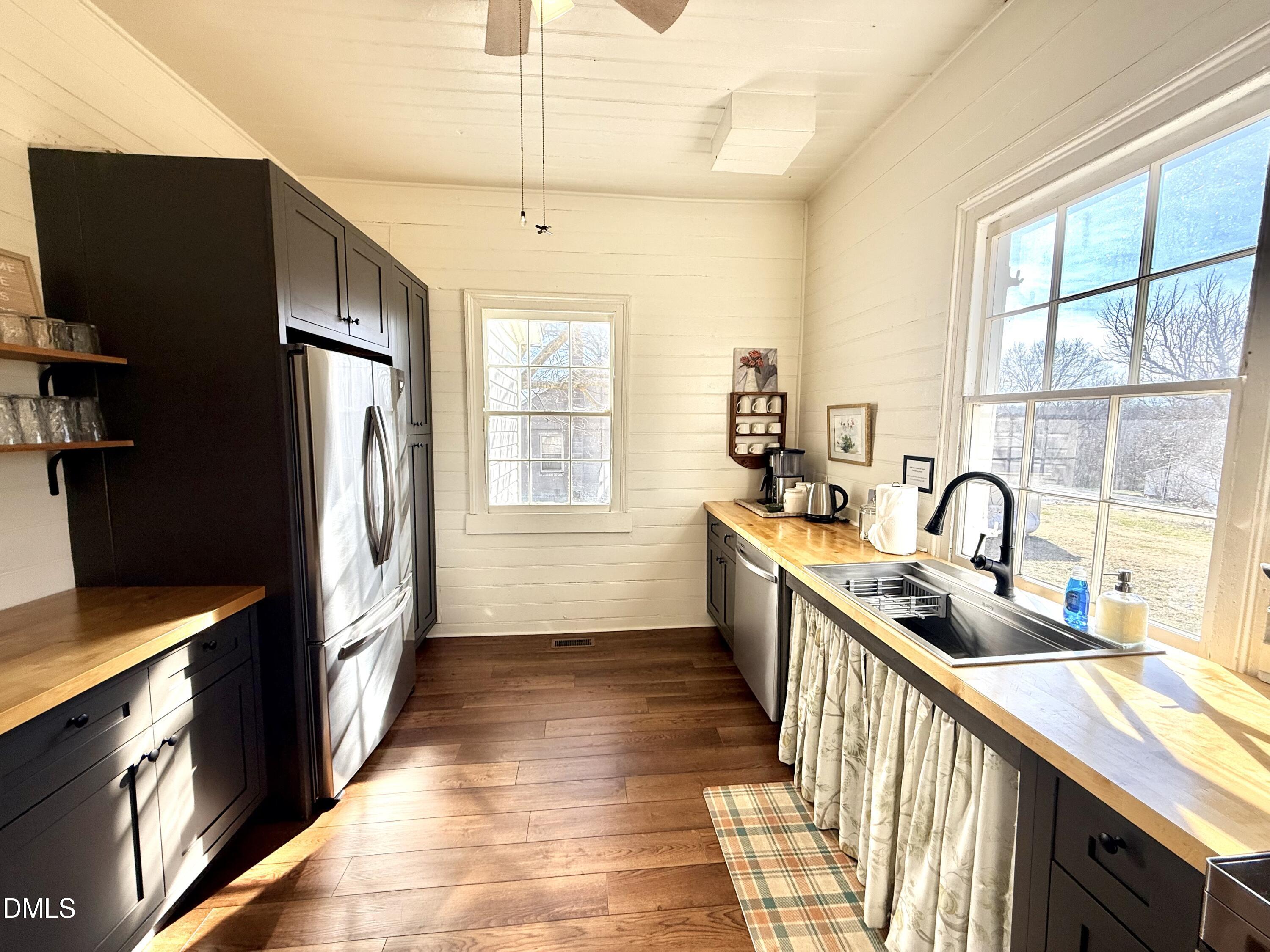 190 Broad Street Milton, NC 27305 - Photo 7 of 62 a kitchen with stainless steel appliances granite countertop a refrigerator a sink dishwasher a stove and white countertops with wooden floor