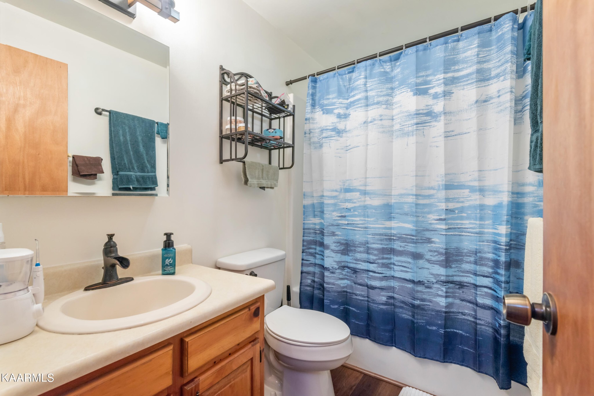 2356 Black Oak Ridge Road Sevierville, TN 37876 - Photo 20 of 33 a bathroom with a white toilet sitting next to a white sink and a shower curtain