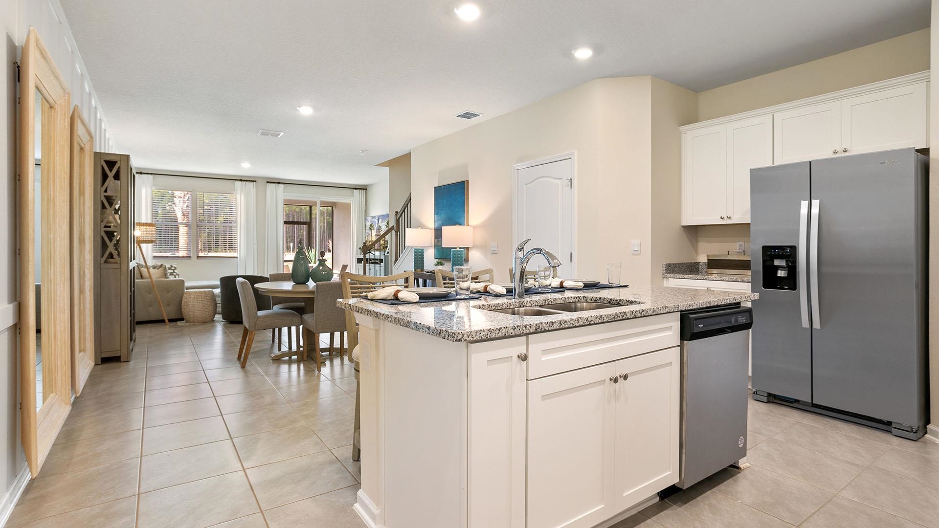 483 Redbud Road Palm Coast, FL 32137 - Photo 4 of 32 a kitchen with stainless steel appliances granite countertop a stove top oven a sink a dining table and chairs