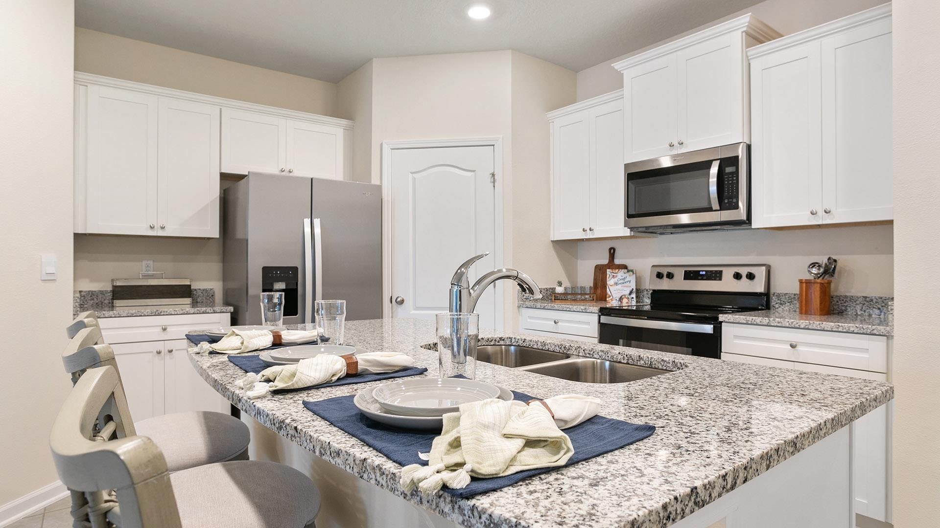 483 Redbud Road Palm Coast, FL 32137 - Photo 5 of 32 a kitchen with stainless steel appliances granite countertop a sink a stove and a refrigerator