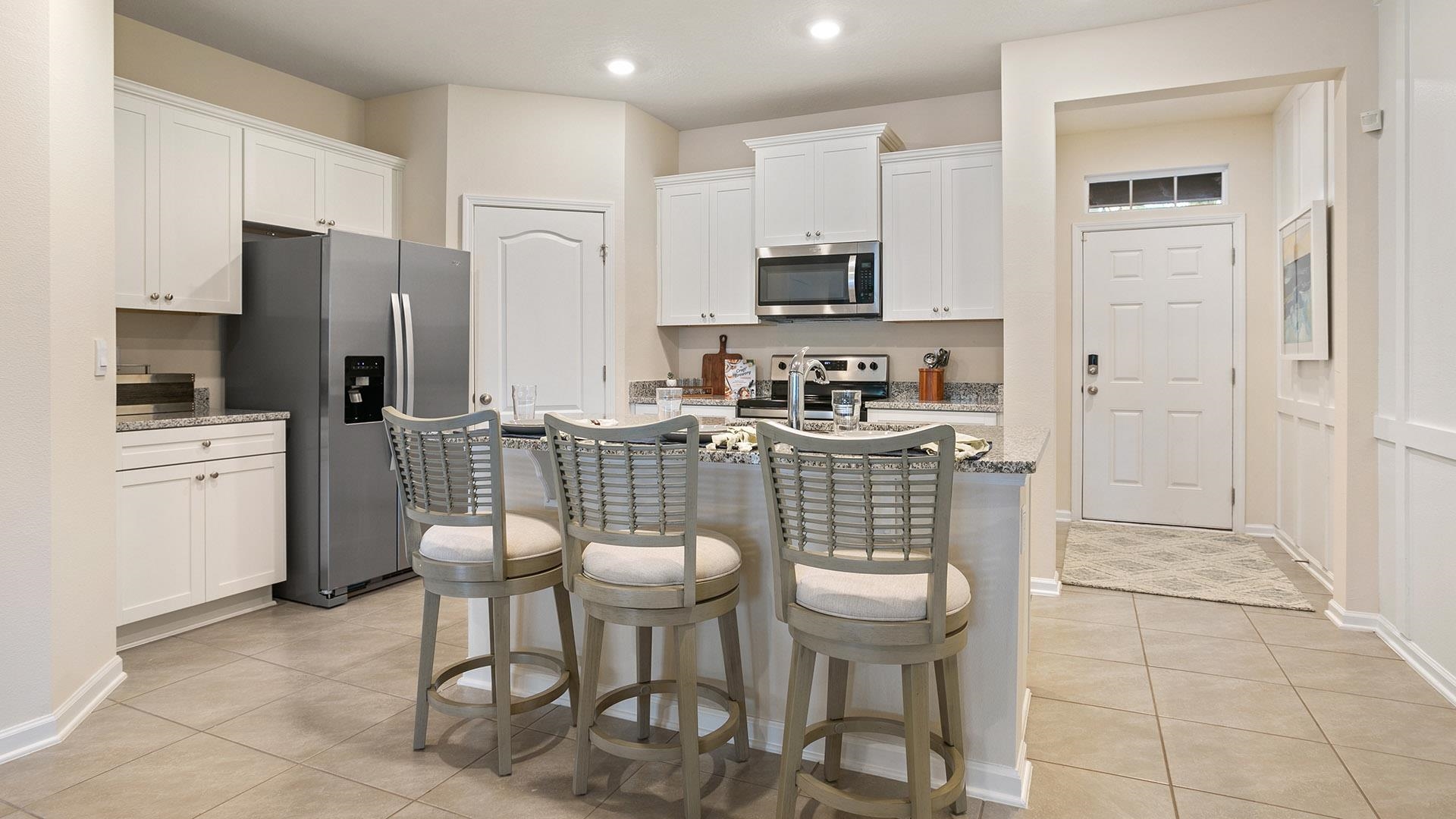 483 Redbud Road Palm Coast, FL 32137 - Photo 6 of 32 a kitchen with stainless steel appliances a stove a sink refrigerator and a microwave
