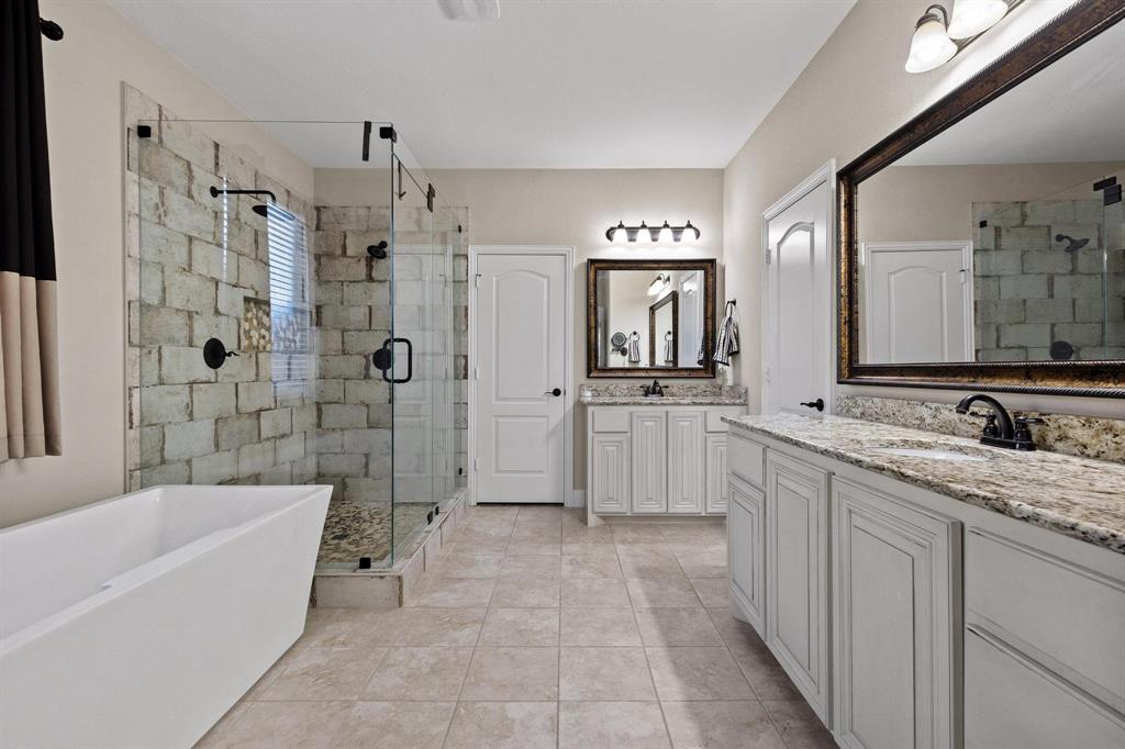 320 Sherbrook Street Van Alstyne, TX 75495 - Photo 15 of 38 Raised vanity cabinets, luxurious free standing deep tub, frameless glass shower, oil rubbed bronze designer Delta Dual lever faucets. Elegant framed mirrors above cabinets. DUAL walk in closets.