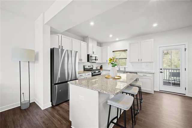 a kitchen with refrigerator cabinets dining table and chairs