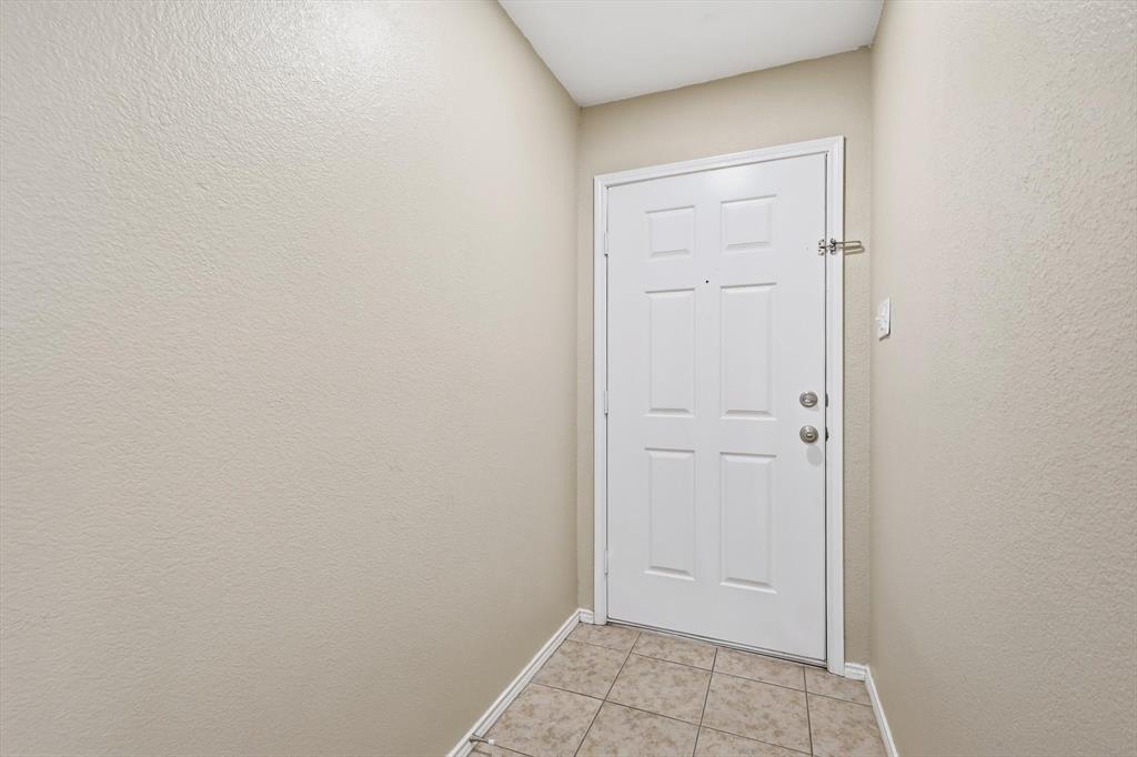 7733 Liz Lane Watauga, TX 76148 - Photo 4 of 27 Doorway with tile patterned floors and a textured wall