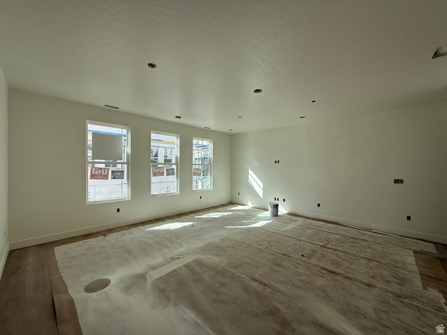 11023 South Freestone Road, Unit 122 South Jordan, UT 84009 - Photo 4 of 12 Spacious room with wood-finish flooring, three large windows, recessed ceiling lighting, and white baseboards
