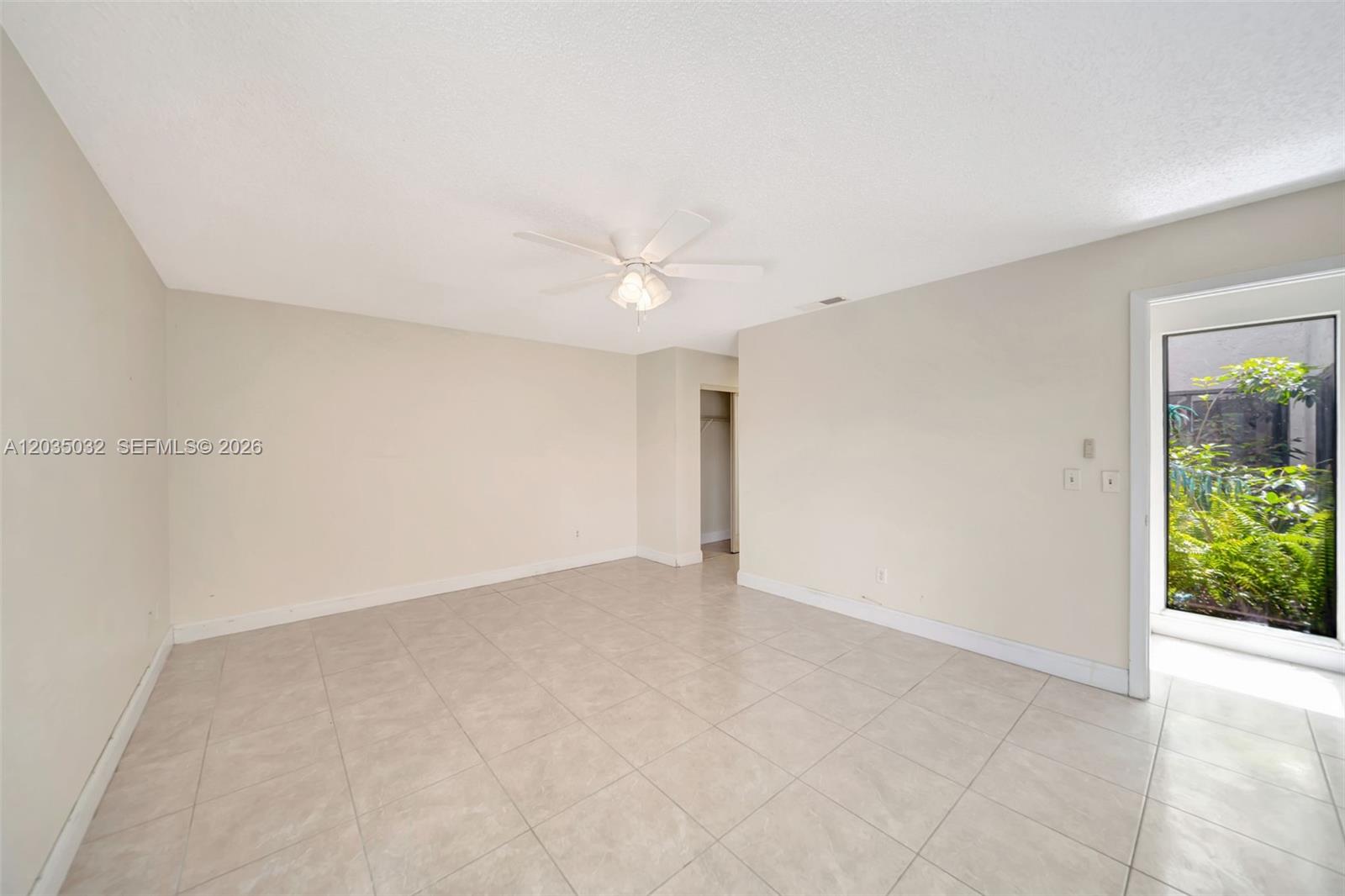 5223 Gate Lake Road, Unit 5223 Tamarac, FL 33319 - Photo 22 of 37 an empty room with a ceiling fan and a window