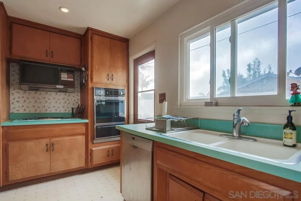 1800 Guevara Road Carlsbad, CA 92008 - Photo 11 of 29 a bathroom with a sink a mirror and a bathtub next to a window