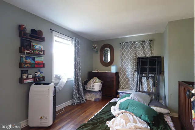 a view of a bedroom with baby crib and hanging floor