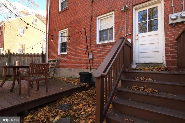 a view of a roof deck with table and chairs with wooden floor and fence