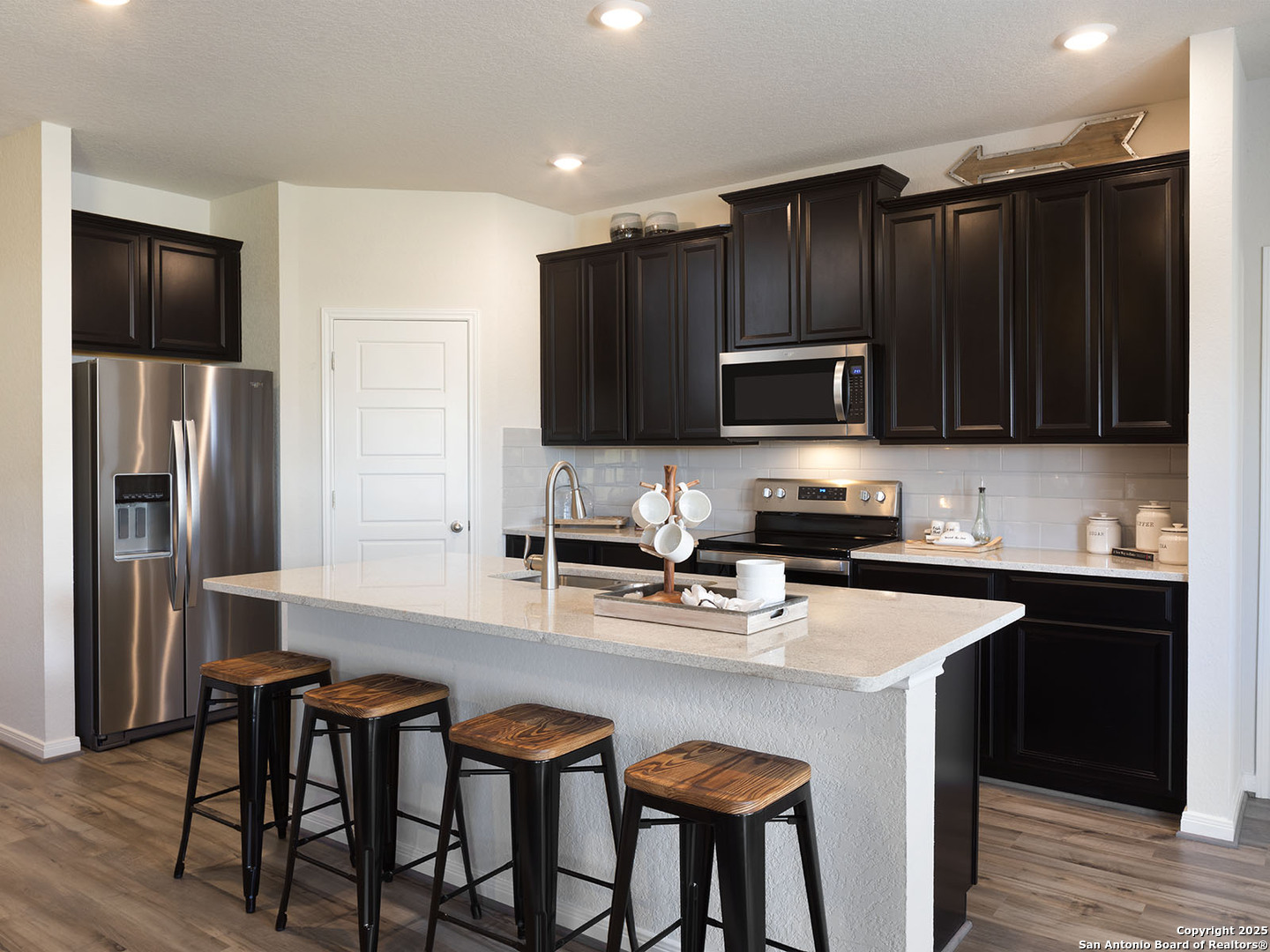 124 Perciful Avenue Cibolo, TX 78108 - Photo 2 of 14 a kitchen with stainless steel appliances wooden cabinets a refrigerator and a stove top oven