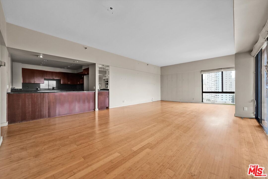 10445 Wilshire Boulevard, Unit 904 Los Angeles, CA 90024 - Photo 11 of 40 a view of a livingroom with wooden floor and kitchen space with a sink