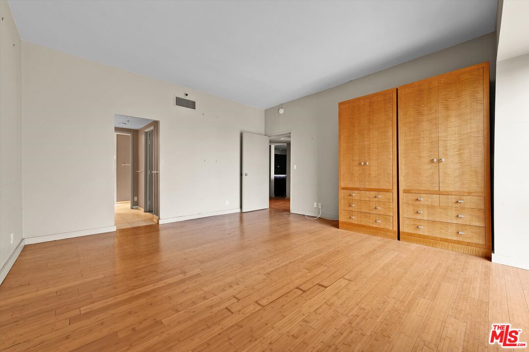 10445 Wilshire Boulevard, Unit 904 Los Angeles, CA 90024 - Photo 19 of 40 a view of an empty room with wooden floor and cabinet
