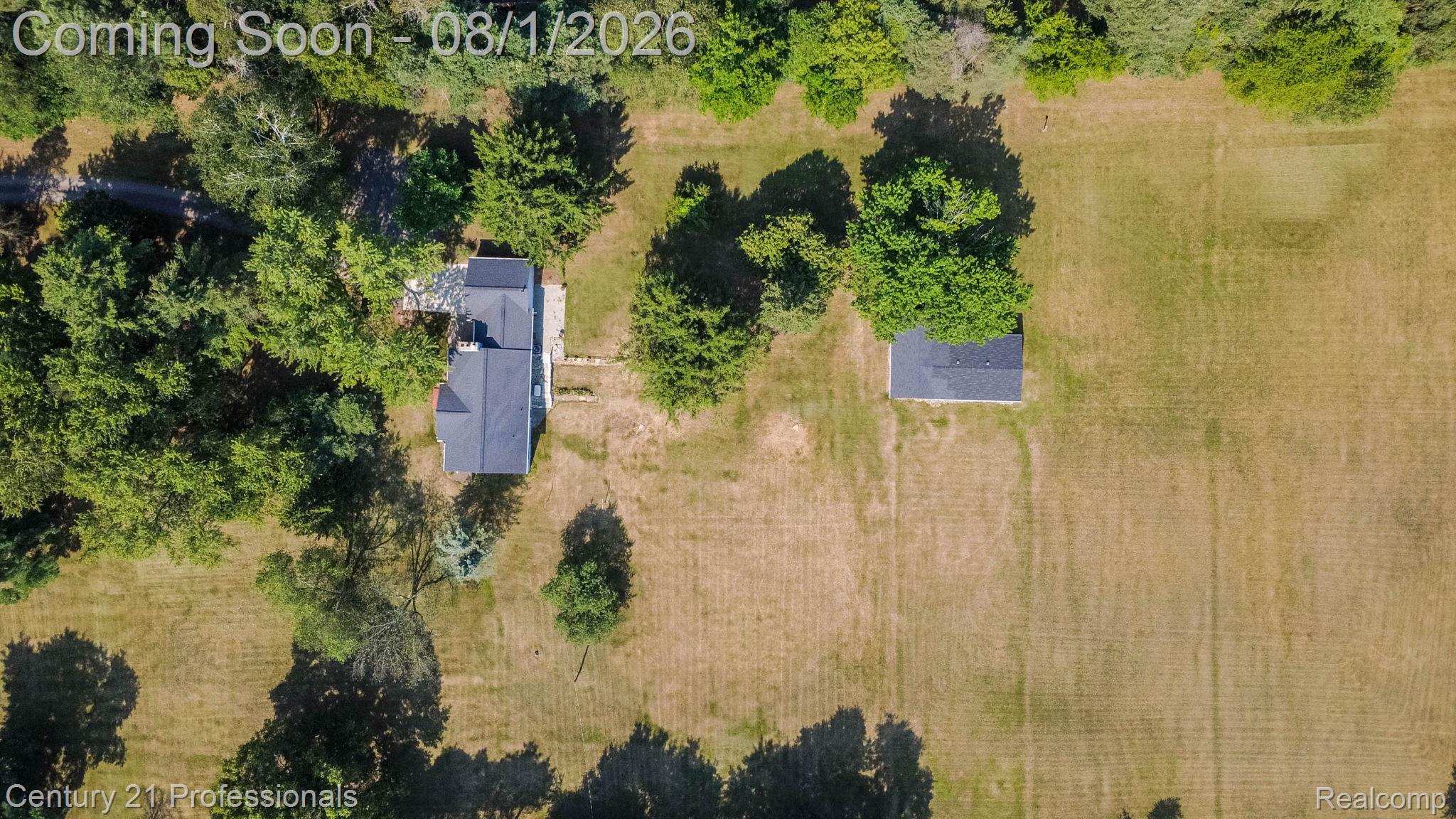 1365 East Buell Road Rochester, MI 48306 - Photo 54 of 56 Aerial perspective showcasing a main residence with a dark-pitched roof, a separate detached structure, and expansive surrounding open land