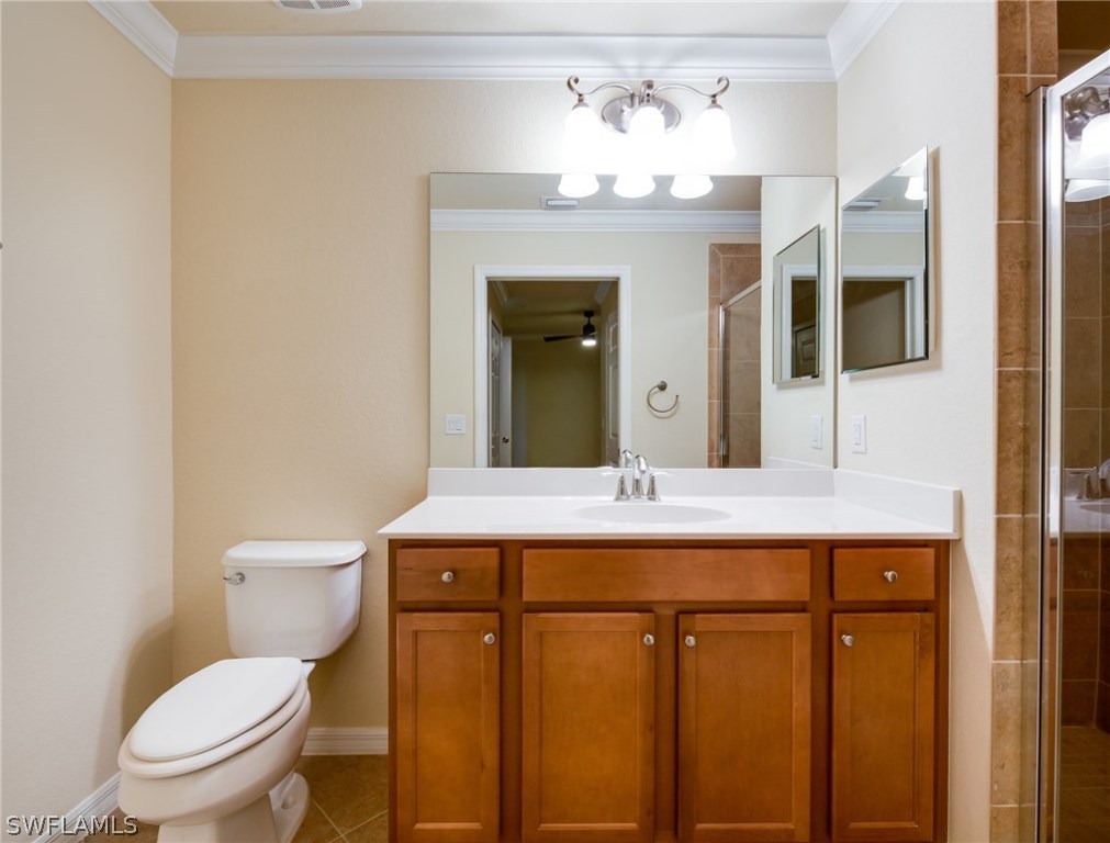 9727 Acqua Court, Unit 413 Naples, FL 34113 - Photo 15 of 35 a bathroom with a toilet a sink and mirror