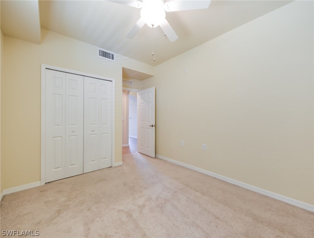 9727 Acqua Court, Unit 413 Naples, FL 34113 - Photo 16 of 35 an empty room with a ceiling fan