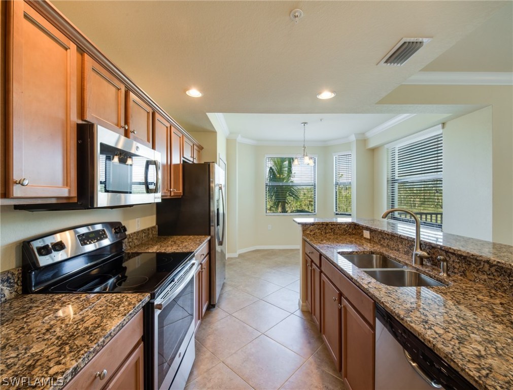 9727 Acqua Court, Unit 413 Naples, FL 34113 - Photo 2 of 35 a kitchen with granite countertop kitchen island stainless steel appliances a sink stove and a window