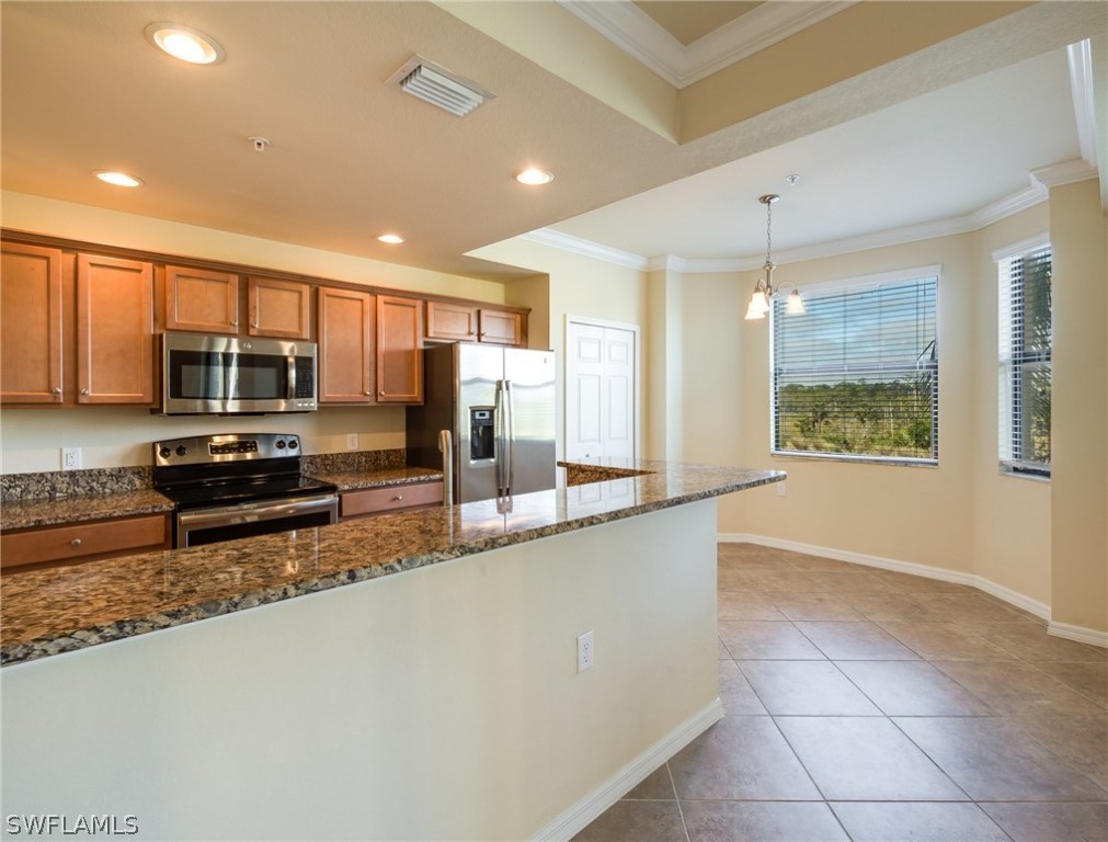 9727 Acqua Court, Unit 413 Naples, FL 34113 - Photo 3 of 35 a large kitchen with kitchen island granite countertop a large window and a counter top space