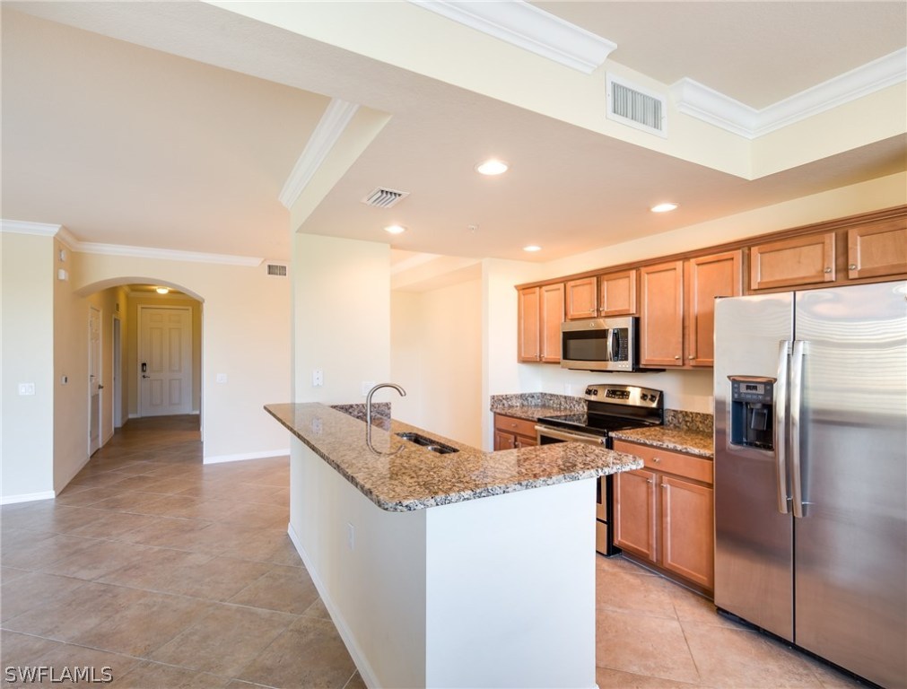 9727 Acqua Court, Unit 413 Naples, FL 34113 - Photo 5 of 35 a kitchen with stainless steel appliances granite countertop a refrigerator a stove and a sink