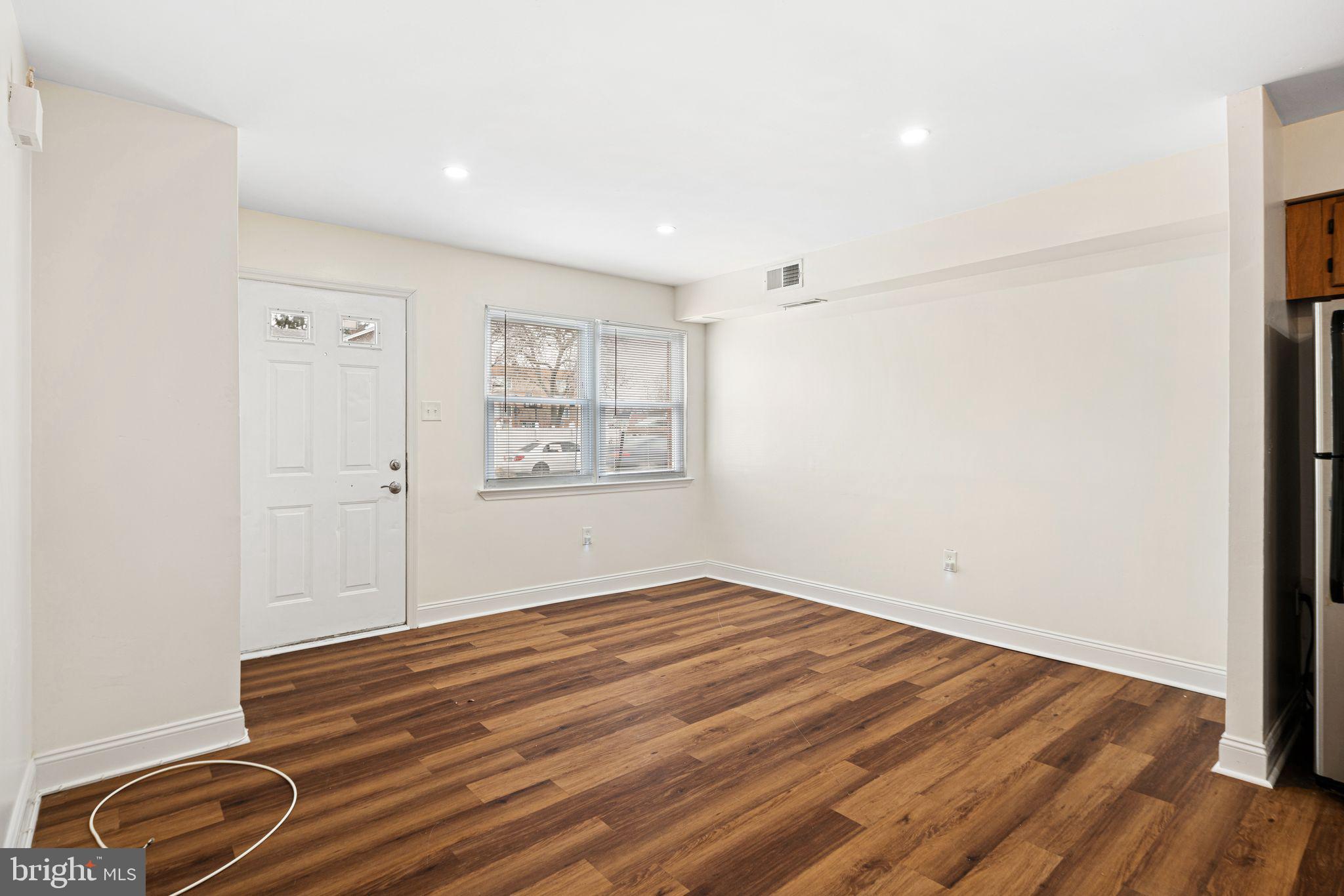 7926 Cottage Street Philadelphia, PA 19136 - Photo 5 of 29 an empty room with wooden floor cabinet and windows