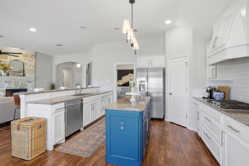 7224 Prestwick Terrace Benbrook, TX 76126 - Photo 9 of 26 Gourmet spacious kitchen with oversized breakfast bar, walk in pantry, and beautiful blue island as a unqiue focal point. This kitchen provides a seamless flow into the living area, perfect for hosting and everyday living.