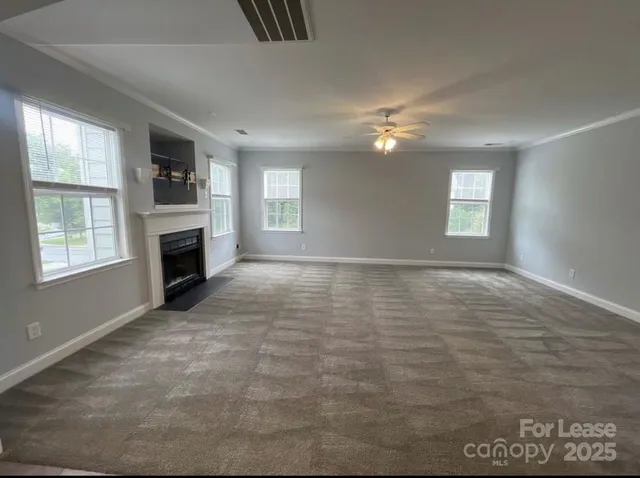 a view of empty room with a fireplace and window