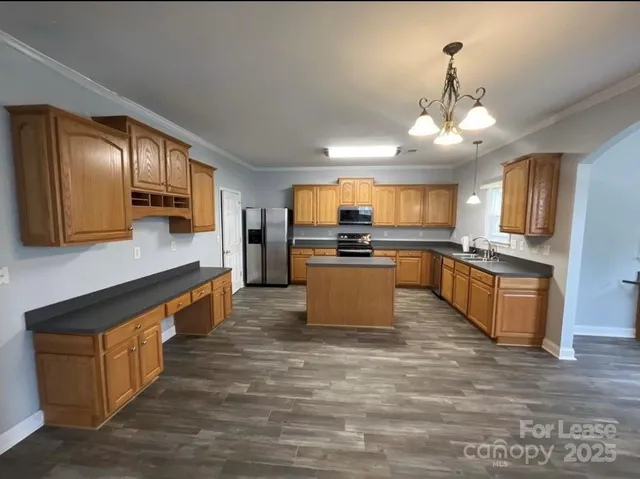 a kitchen with stainless steel appliances granite countertop a refrigerator sink and stove
