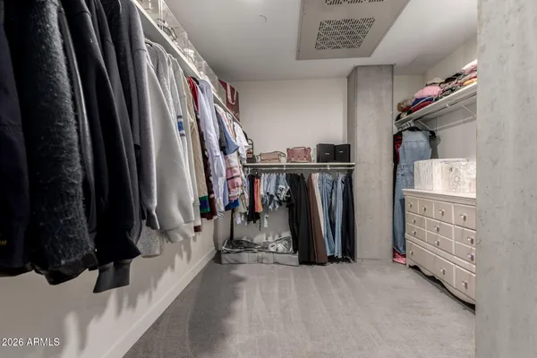 a view of walk in closet with clothes and shoes