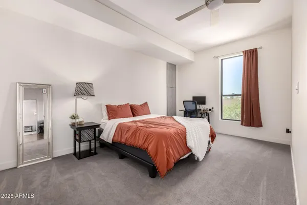 a spacious bedroom with a bed and a dresser