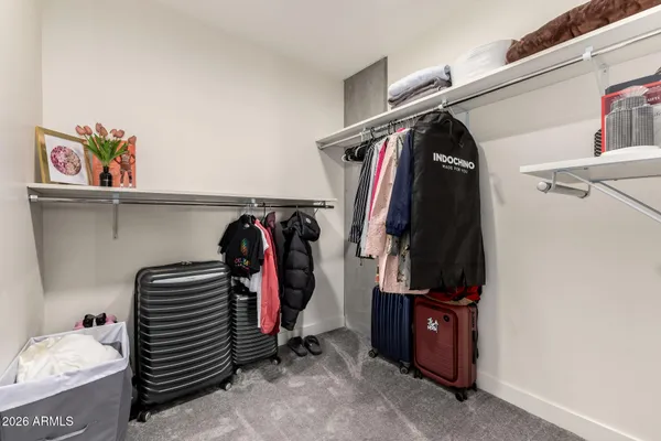 a view of walk in closet with clothes and shoes