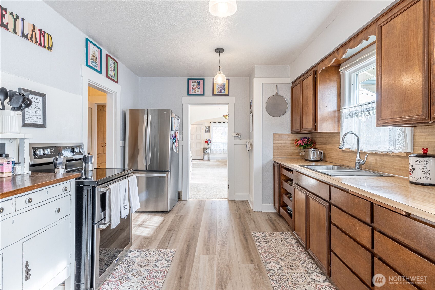 318 4th Street Southwest Puyallup, WA 98371 - Photo 17 of 40 a kitchen with stainless steel appliances a refrigerator a sink dishwasher a oven with wooden cabinets and floor