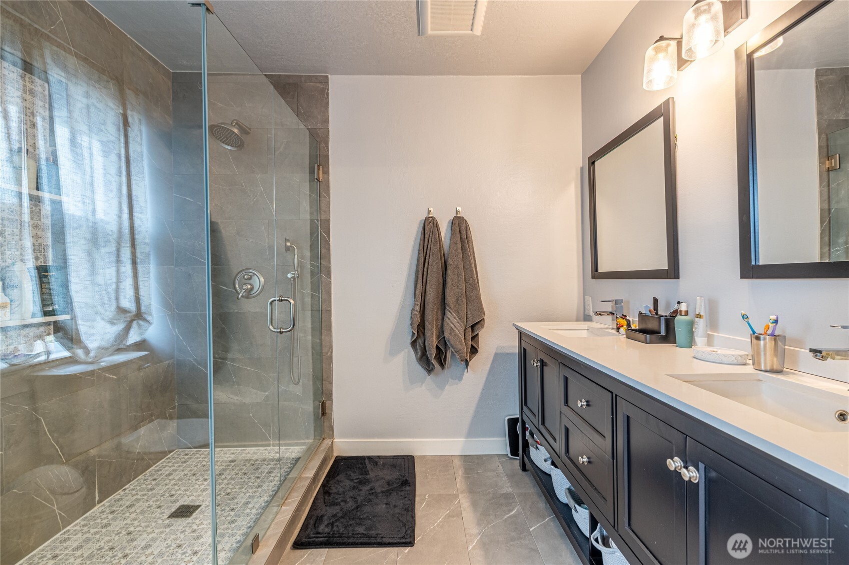 318 4th Street Southwest Puyallup, WA 98371 - Photo 25 of 40 a bathroom with a double vanity sink a mirror and a shower