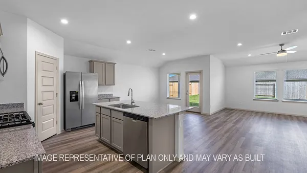 a kitchen with stainless steel appliances granite countertop a refrigerator a sink dishwasher a stove and a dining table with wooden floor