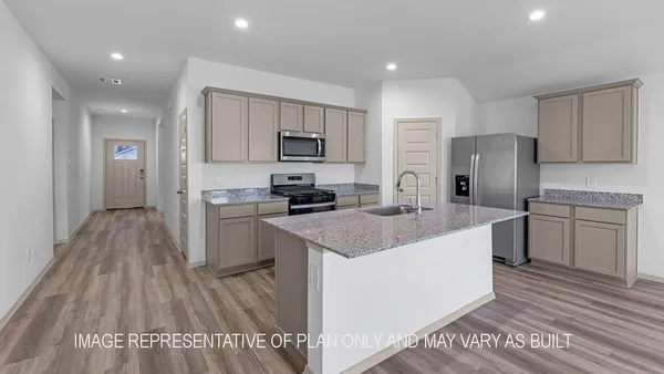 a kitchen with kitchen island granite countertop a sink stove and refrigerator